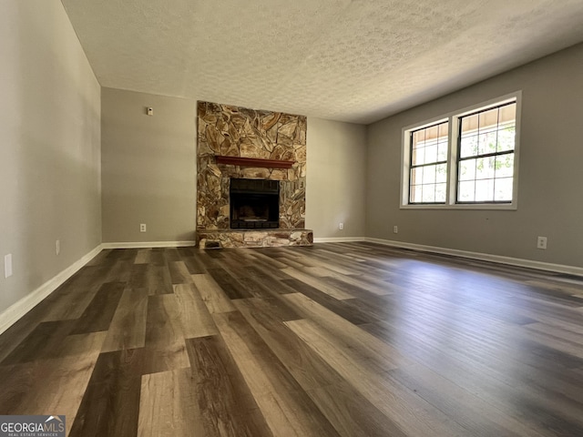 2045 Greentree Pkwy, Macon, GA 31220 - unfurnished living room with baseboards, a textured ceiling, dark wood-style floors, and a fireplace