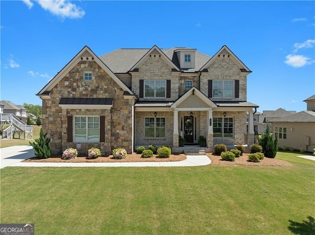 craftsman inspired home with stone siding and a front lawn