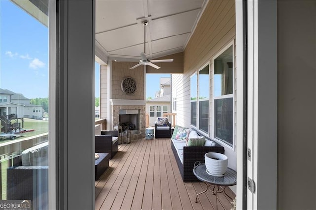 wooden terrace featuring an outdoor living space with a fireplace and ceiling fan