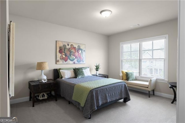 bedroom featuring light carpet, visible vents, and baseboards