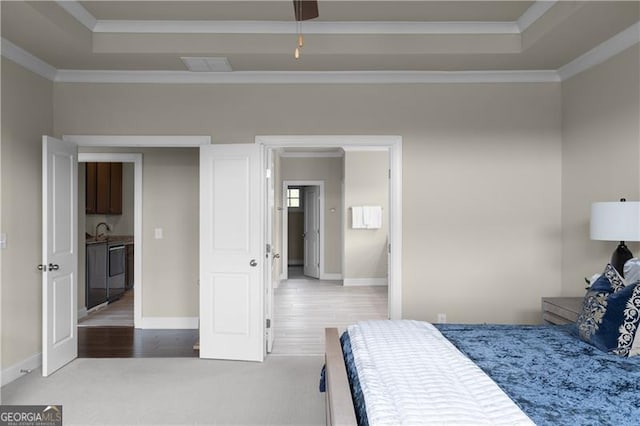 bedroom with crown molding, carpet flooring, a tray ceiling, and visible vents