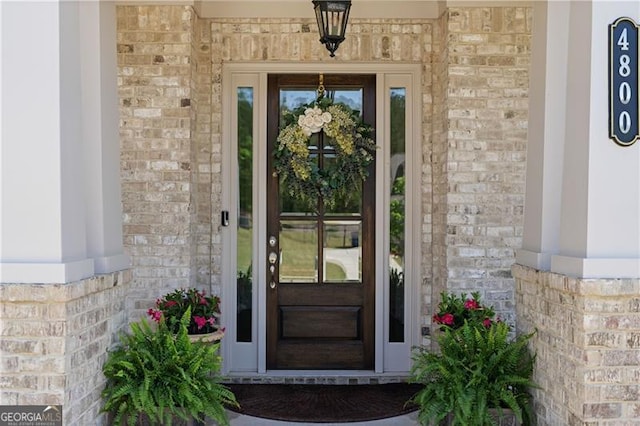 doorway to property with brick siding