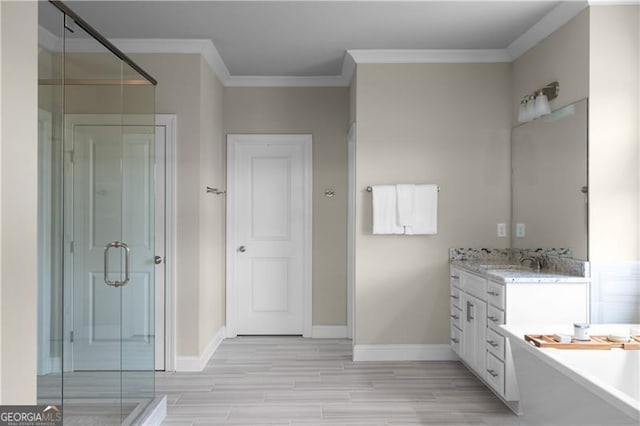 bathroom with a stall shower, vanity, a freestanding tub, wood finish floors, and ornamental molding