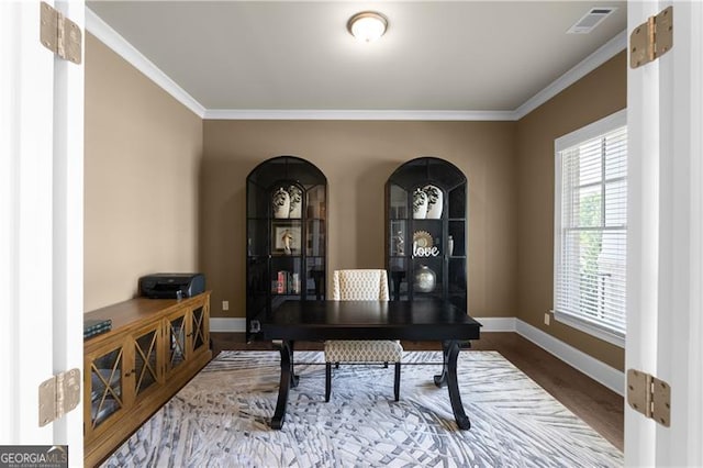 home office with wood finished floors, visible vents, crown molding, and baseboards