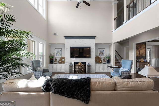 living room featuring a high ceiling, a ceiling fan, and a wealth of natural light