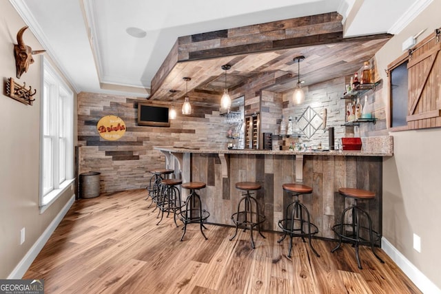 1985 Chapel Estates Ln, Dacula, GA 30019 - indoor wet bar featuring wood finished floors, a barn door, hanging light fixtures, and an accent wall