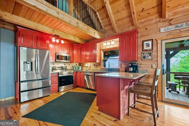 399 Ranch Mountain Dr, Dahlonega, GA 30533 - kitchen featuring decorative backsplash, a peninsula, dark brown cabinets, light wood finished floors, and appliances with stainless steel finishes