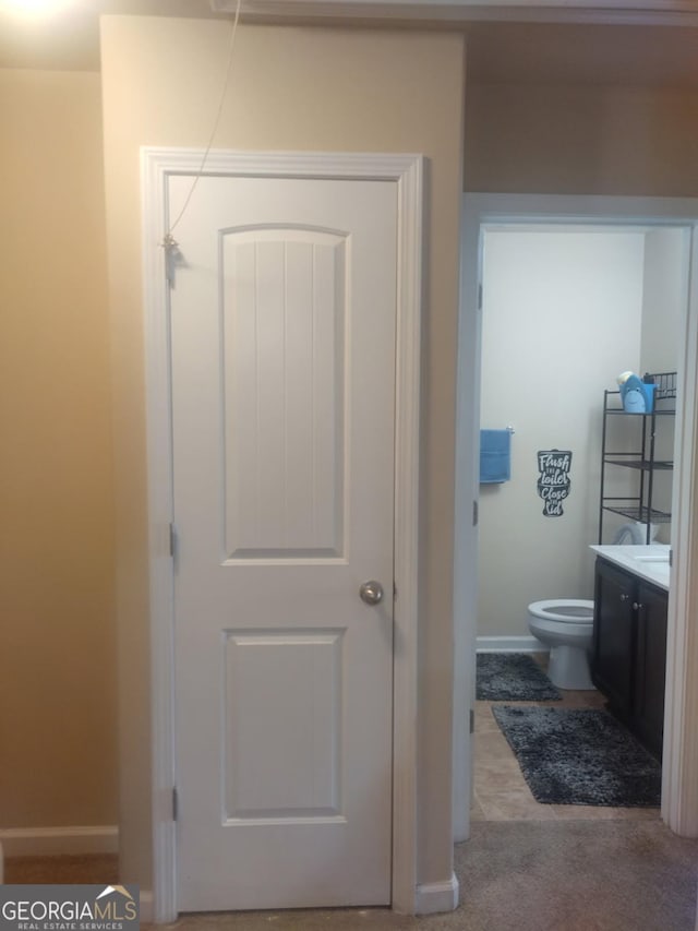 bathroom featuring vanity, baseboards, and toilet