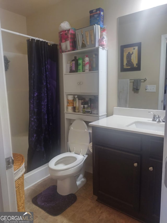 bathroom featuring vanity, tile patterned floors, a stall shower, and toilet