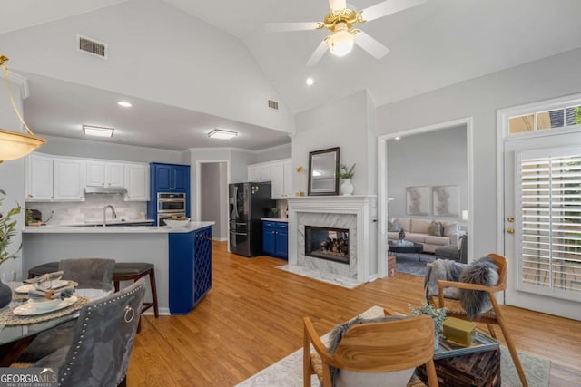 500 Meadowmeade Ln, Lawrenceville, GA 30043 - living area featuring a high end fireplace, light wood-style floors, a ceiling fan, high vaulted ceiling, and recessed lighting