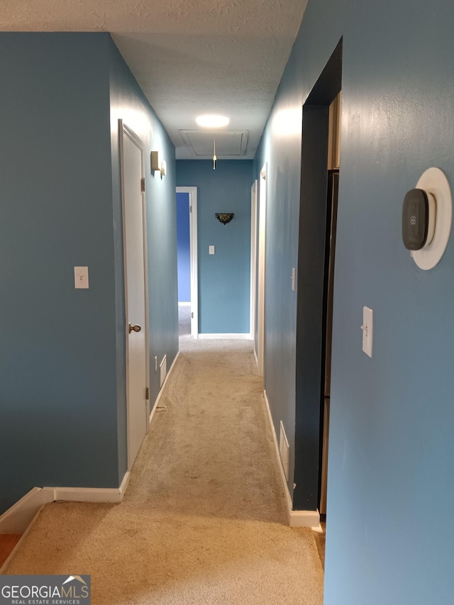 4616 Hamlet Walk SE, Conyers, GA 30094 - hallway with attic access, carpet flooring, baseboards, and a textured ceiling