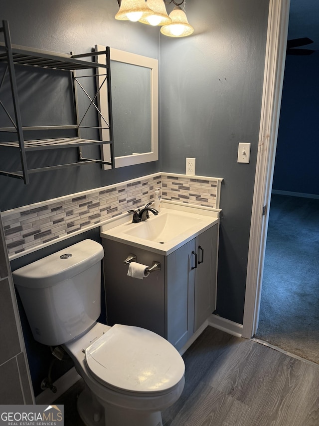 4616 Hamlet Walk SE, Conyers, GA 30094 - bathroom with vanity, toilet, wood finished floors, backsplash, and baseboards