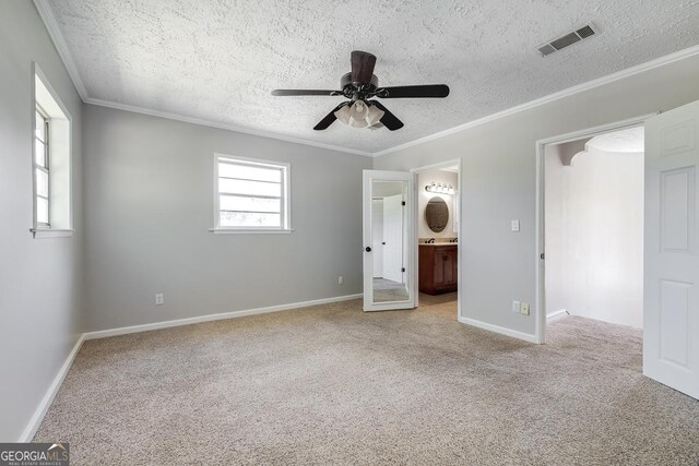 203 N Lake Dr, Brunswick, GA 31525 - unfurnished bedroom featuring crown molding, a textured ceiling, carpet floors, baseboards, and visible vents