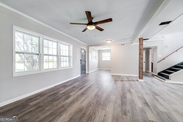 203 N Lake Dr, Brunswick, GA 31525 - unfurnished living room featuring visible vents, baseboards, wood finished floors, stairs, and ceiling fan