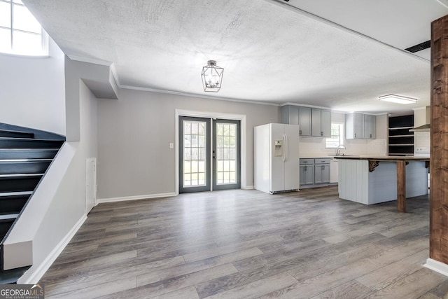 203 N Lake Dr, Brunswick, GA 31525 - interior space featuring dark wood finished floors, ornamental molding, baseboards, a textured ceiling, and stairs