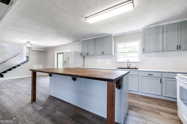 203 N Lake Dr, Brunswick, GA 31525 - kitchen with a textured ceiling, a sink, wooden counters, white appliances, and gray cabinetry