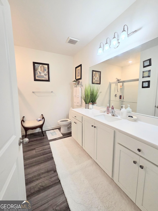 288 Mccall Way, Monroe, GA 30655 - bathroom with a shower stall, wood finished floors, vanity, toilet, and visible vents