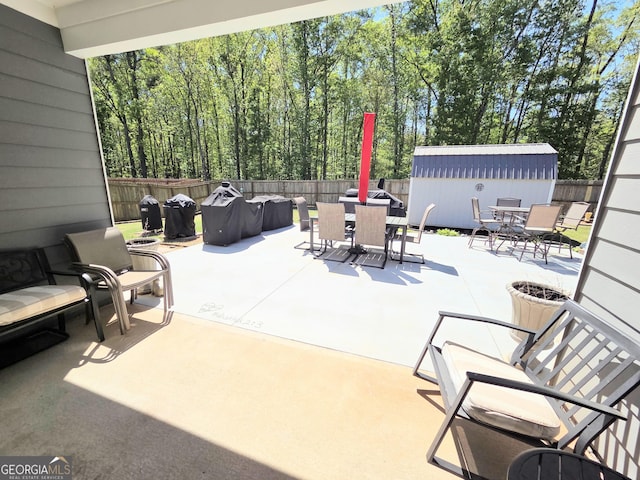 288 Mccall Way, Monroe, GA 30655 - view of patio / terrace featuring a fenced backyard, outdoor dining space, and a storage shed