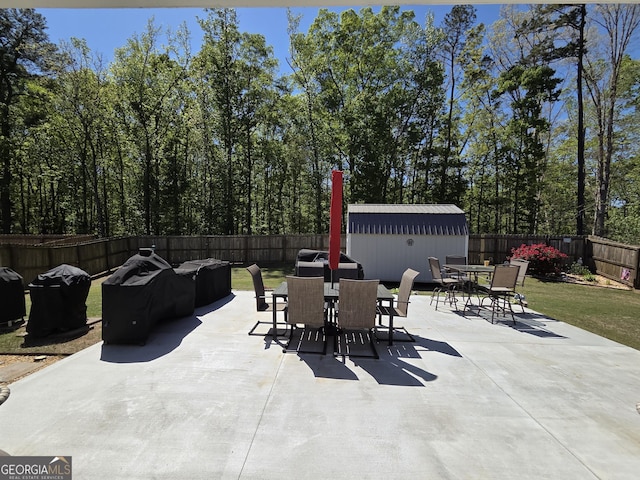 288 Mccall Way, Monroe, GA 30655 - view of patio with a fenced backyard, an outbuilding, and outdoor dining space