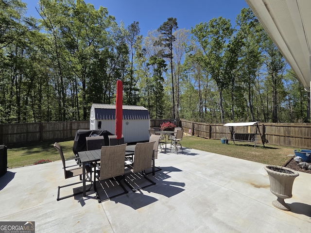 288 Mccall Way, Monroe, GA 30655 - view of patio / terrace featuring a storage shed, a fenced backyard, outdoor dining area, and an outdoor structure