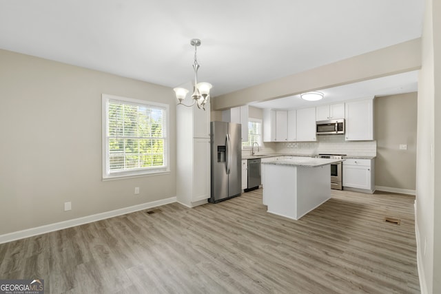 1825 SW Willis Mill Rd, Atlanta, GA 30311 - kitchen with light wood-type flooring, a sink, a notable chandelier, and appliances with stainless steel finishes