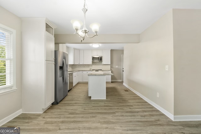 1825 SW Willis Mill Rd, Atlanta, GA 30311 - kitchen featuring stainless steel appliances, an inviting chandelier, a center island, tasteful backsplash, and white cabinetry