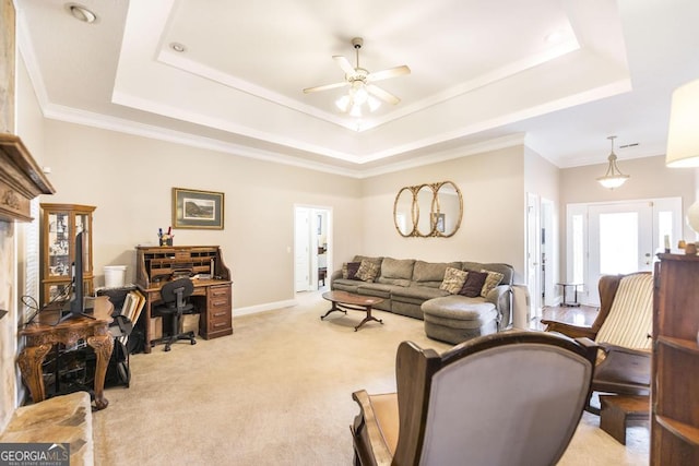 living area featuring light carpet, a ceiling fan, and a tray ceiling