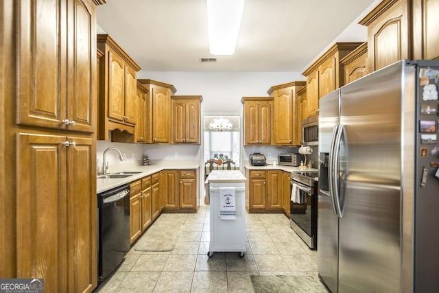 kitchen featuring a sink, brown cabinetry, light tile patterned floors, stainless steel appliances, and light countertops