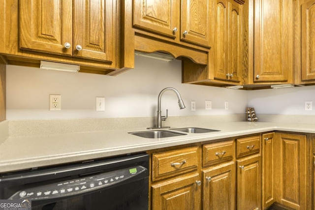 kitchen with brown cabinets, black dishwasher, and a sink