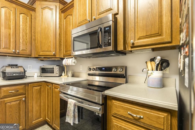 kitchen with brown cabinetry, a toaster, and stainless steel appliances