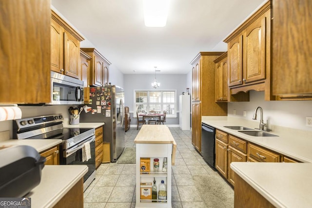 kitchen featuring a sink, brown cabinets, a chandelier, stainless steel appliances, and light countertops