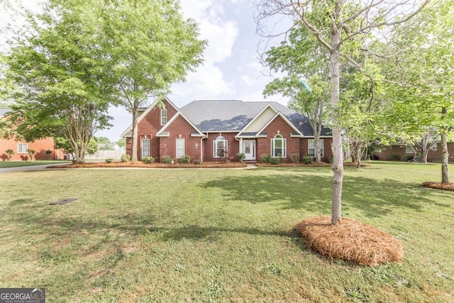 view of front of property with brick siding, roof with shingles, and a front yard