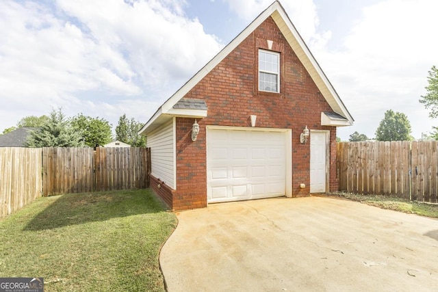 garage with driveway, fence, and a detached garage