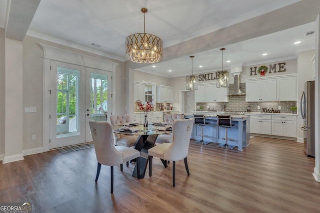 dining room with crown molding, wood finished floors, baseboards, a notable chandelier, and recessed lighting