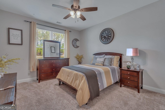 bedroom featuring ceiling fan, baseboards, visible vents, and light carpet