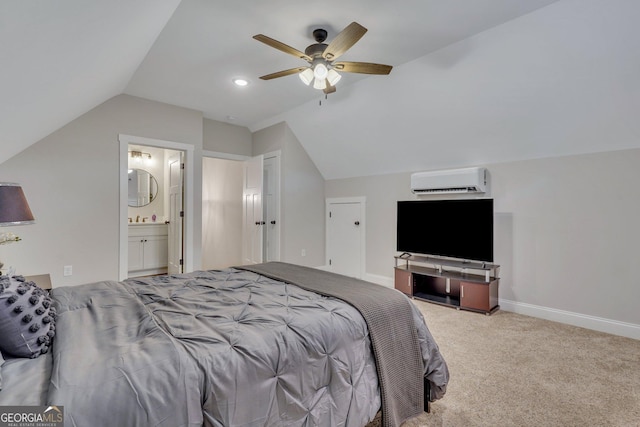 bedroom featuring vaulted ceiling, ensuite bathroom, a wall mounted AC, carpet, and baseboards