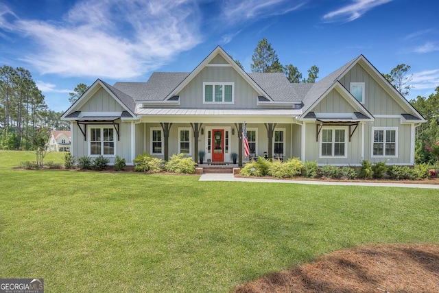craftsman house featuring board and batten siding, a porch, a front lawn, and roof with shingles