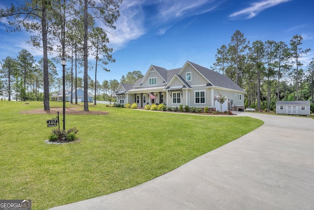 craftsman inspired home with board and batten siding, driveway, a porch, and a front lawn