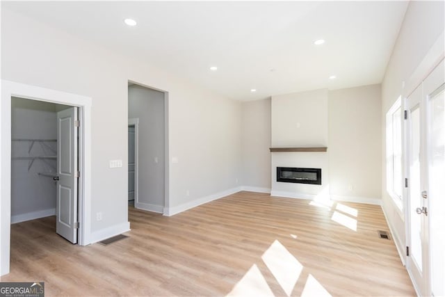 3286 Bachelor St, East Point, GA 30344 - unfurnished living room featuring baseboards, recessed lighting, a glass covered fireplace, and light wood-type flooring