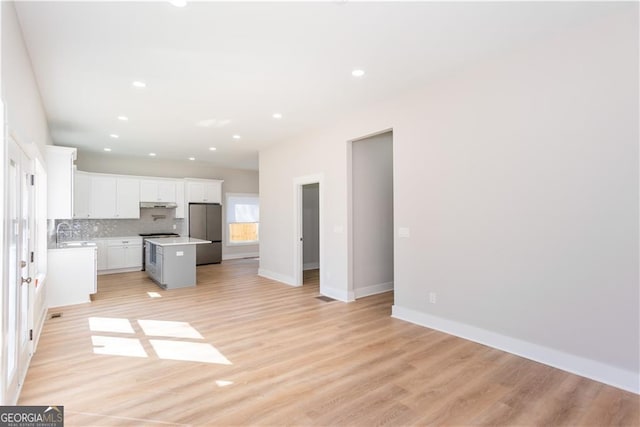 3286 Bachelor St, East Point, GA 30344 - unfurnished living room featuring light wood-style flooring, baseboards, recessed lighting, and a sink