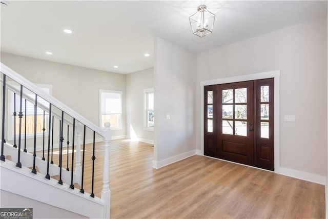 3286 Bachelor St, East Point, GA 30344 - foyer entrance with baseboards, light wood-type flooring, stairs, and an inviting chandelier