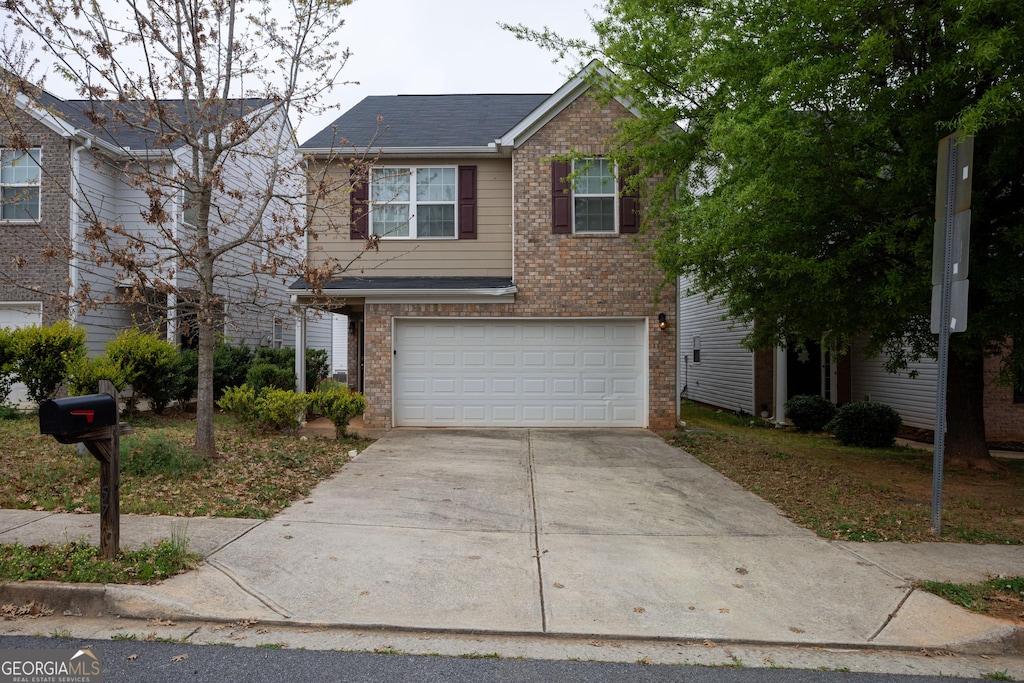 traditional home with a garage, brick siding, and concrete driveway