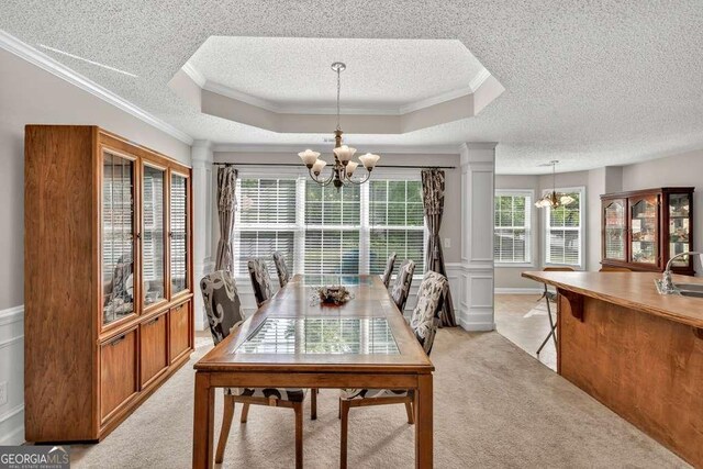 180 Laurel Oaks Ln, Jefferson, GA 30549 - dining room featuring a chandelier, a textured ceiling, ornamental molding, light carpet, and ornate columns