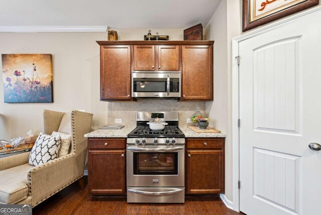 1635 Hampton Oaks Dr, Alpharetta, GA 30004 - kitchen featuring appliances with stainless steel finishes, backsplash, dark wood-style floors, light stone counters, and crown molding