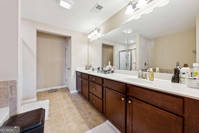 full bathroom with double vanity, visible vents, tile patterned floors, and a sink