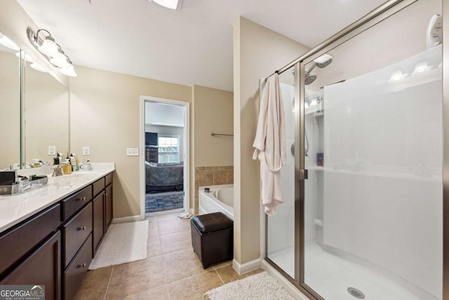 full bath with tile patterned floors, vanity, ensuite bath, baseboards, and a stall shower