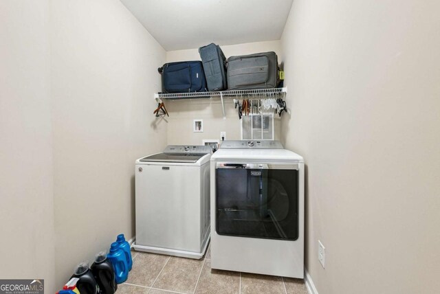 laundry room featuring separate washer and dryer, laundry area, and light tile patterned floors