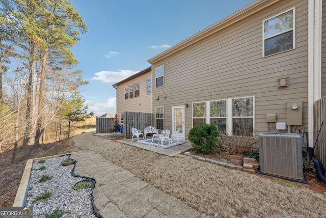 rear view of house with fence, a patio area, and central air condition unit