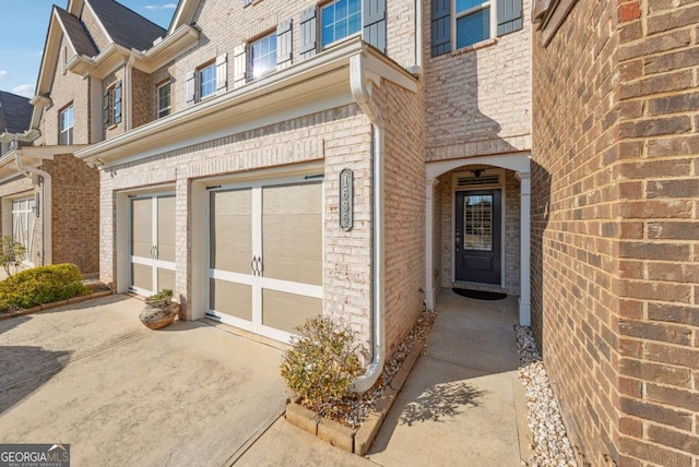 1635 Hampton Oaks Dr, Alpharetta, GA 30004 - view of exterior entry with a garage, brick siding, and driveway