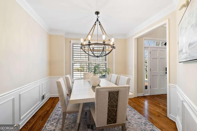 720 Lakeglen Dr, Suwanee, GA 30024 - dining room with a chandelier, dark wood-type flooring, ornamental molding, a wainscoted wall, and a decorative wall